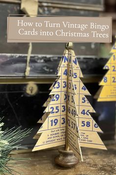 a wooden christmas tree with numbers on it and the words how to turn vintage bingo cards into christmas trees