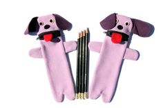 two stuffed dogs holding pencils in their mouths