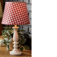 a red and white checkered lamp sitting on top of a wooden table