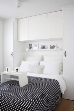 a white bedroom with black and white bedspread