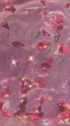 some flowers floating in water with bubbles