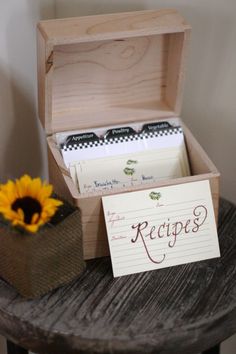 an open wooden box with recipe cards and a sunflower