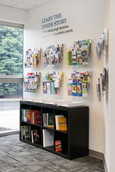 a book shelf with many books on it in front of a large window that reads learn the inside story