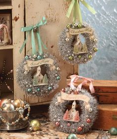 three christmas wreaths with ornaments hanging from them