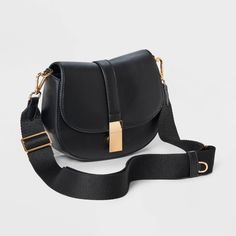 This Saddle Crossbody Bag from A New Day™ with a structured silhouette features a roomy main compartment and an interior zip pocket for easy organization of your belongings, plus an overlapping flap with a gold-tone buckle accent and magnetic closure. Plus, the detachable adjustable shoulder strap makes carrying a breeze whether you sling it over one shoulder or carry it in hand. A New Day™: Style that goes wherever you do. Gold Shoulder Bag With Adjustable Strap For Work, Gold Crossbody Bag For Work, Versatile Saddle Bag With Gold-tone Hardware For Travel, Versatile Travel Saddle Bag With Gold-tone Hardware, Gold Bags With Magnetic Closure For Work, Gold Crossbody Saddle Bag With Adjustable Strap, Saddle Crossbody Bag, Top Handle Handbags, Easy Organization