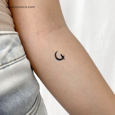 a woman's arm with a small crescent tattoo on the left side of her arm