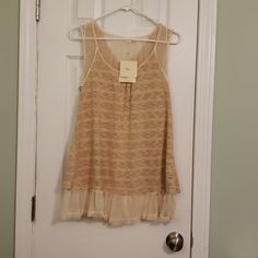 Rayon And Polyester Beige Sleeveless Tank With Open Back Sheer And Lace Detail And Sheer Pleats On Hemline. Chic Beige Tank Top With Lace Trim, Chic Beige Lace Trim Tank Top, Feminine Beige Lace Trim Tank Top, Beige Sleeveless Summer Tank Top, Beige Sleeveless Tank Top For Summer, Beige Bohemian Tank Top For Day Out, Spring Beige Tank Camisole, Feminine Apricot Sleeveless Top, Spring Beige Vest Camisole