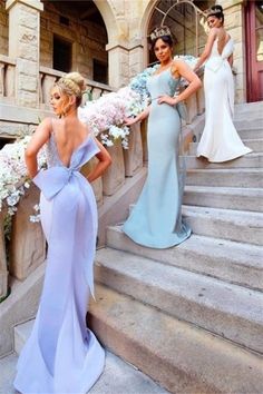 three beautiful women standing on the steps in front of some stairs with flowers around them