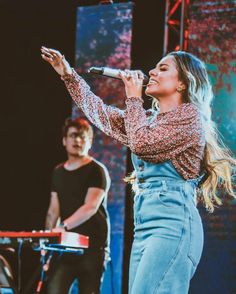 a woman standing on top of a stage holding a microphone