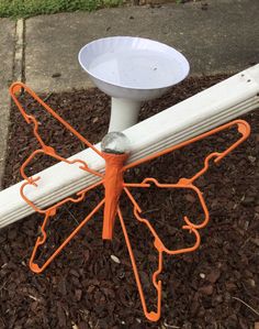 an orange and white object sitting on top of mulch next to a street sign