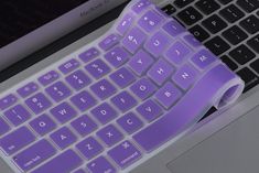 a purple keyboard on top of a laptop computer