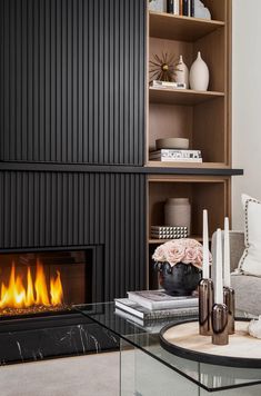 a living room filled with furniture and a fire place in front of a book shelf