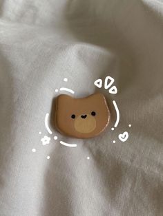 a brown teddy bear sitting on top of a white sheet