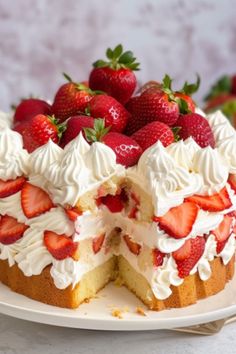 a cake with strawberries and whipped cream on top sits on a white platter