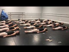 a group of people laying on their stomachs in the middle of a dance studio