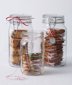 three glass jars filled with cookies on top of a table