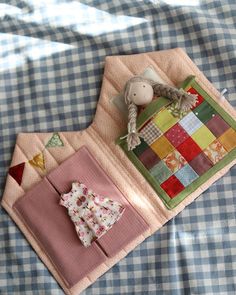 a patchwork table cloth with a doll and fabric on it sitting on a bed