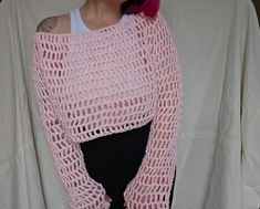 a woman with pink hair wearing a pink knitted sweater