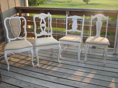 four white chairs sitting on top of a wooden deck