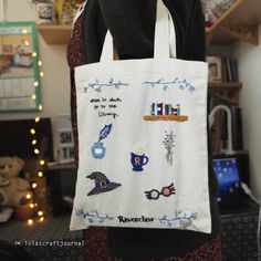 a person holding a bag with embroidered images on it