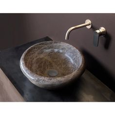 a bathroom sink that has a marble bowl on the top and a metal faucet