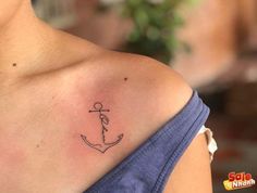 a woman with a tattoo on her shoulder has an anchor in the middle of it