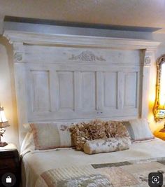 a bed with white headboard and pillows on it