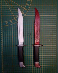 two knives on a cutting board with a ruler in the middle and another knife to the side