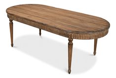 an oval wooden table with carved legs and wood grained finish on the top, against a white background