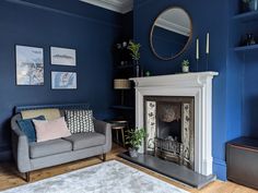 a living room filled with furniture and a fire place in front of a blue wall