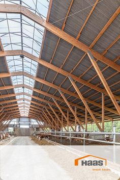 the inside of a large building with wooden beams and windows on it's sides