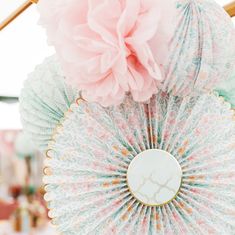 decorative paper fans with pink flowers hanging from them