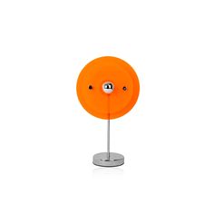 an orange table lamp on a metal stand with two balls in the center and one ball at the base