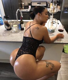 a woman sitting at a counter with a glass of wine in front of her back