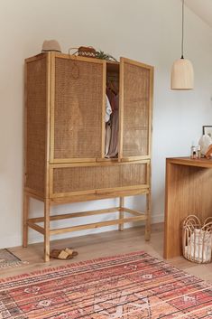 a wooden cabinet sitting next to a rug on top of a hard wood floor in a room