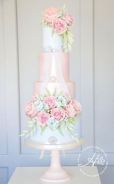 a three tiered cake with pink and white flowers