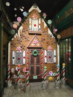 a gingerbread house decorated with candy canes and candies for the holiday season