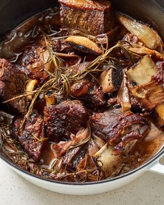 a pot filled with meat and vegetables on top of a table