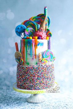 a multicolored birthday cake with sprinkles and candies on top