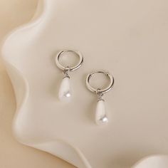 Introducing our Pearl Teardrop Huggies, featuring dainty hoop earrings with lustrous pearls that gracefully dangle. These earrings are the perfect accessory for a beach wedding, offering a timeless elegance that complements any bridal look. Embrace the romance of the seaside and add a touch of coastal charm to your special day with these delicate earrings. SKU: RR-ER522 Product Details Material: High Quality Solid 925 Sterling Silver Finish: 18K Gold ∙ Sterling Silver Hoop Dimensions: ~8mm Inner Initial Tag Necklace, Dainty Initial Necklace, Dainty Hoop Earrings, Diamond Huggies, Coastal Charm, Pearl Collection, Bridal Look, The Seaside, Pearl Charms