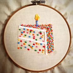 a birthday cake with sprinkles and a candle on it in a hoop