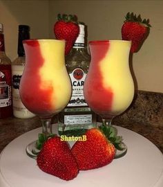 two glasses filled with liquid and strawberries