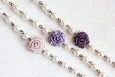 three necklaces with flowers and pearls on them