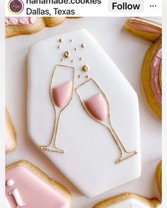 two champagne glasses on top of a cookie next to cookies