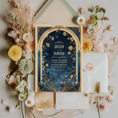 the wedding stationery is laid out on top of flowers and other items, including an envelope