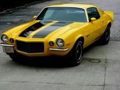 a yellow and black car is parked on the street