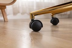 two black wheels on a wooden floor next to a chair