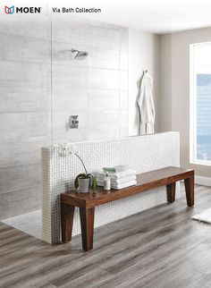 a wooden bench sitting in front of a white tiled wall next to a bath tub