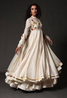 Editor's Note Chanderi Anarkali With Chanderi Dupatta Paired Up With Churidar Color: Ivory Fabric: Chanderi & Cotton Care: Dry Clean Only About the Designer Rohit Bal is intensely concerned with design as an art form. The designer draws on history, fantasy and folklore to create masterpieces that are desired by discerning aficionados around the globe. Rohit has a deep understanding of the psyche of the fashion world and it reflects in his collections that are intelligent, studied, imaginative an Luxury Cotton Silk Anarkali Set With Intricate Embroidery, Luxury Anarkali Set With Pallu, Luxury Anarkali Chikankari Embroidered Fabric, Luxury Anarkali Chinon Palazzo Set, Luxury Anarkali Salwar Kameez With Motifs, Luxury Cotton Anarkali Salwar Kameez, Luxury Anarkali Embroidered Dress In Raw Silk, Luxury Anarkali Style Chanderi Sharara, Luxury Anarkali Choli In Organza