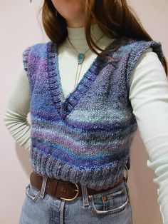 "This luxury silk mohair and wool v-beck sweater vest is handknit and features a boxy silhouette. The sweater is made of a wonderful silk and wool blend from Noro yarnss (45% silk, 45% mohair, 10% wool). I love the cool toned washes of purples, blues, grays, and mint greens that stripe through this sweater. The vest is meant to be slightly oversized and will fit womens size XS-M. The vest has a split hem on the sides.  Model is 5'6, 34\" bust, 27\" waist for reference. The vest is hand knit by m Light Green Sweater Vest Outfit, Colourful Sweater Vest, Colored Vest Outfit, Colorful Sweater Vest, Brown Knit Vest Outfit, Wool Sweater Vest, Purple Sweater Vest Outfit, V Neck Sweater Vest Outfit, Crop Sweater Vest Outfit